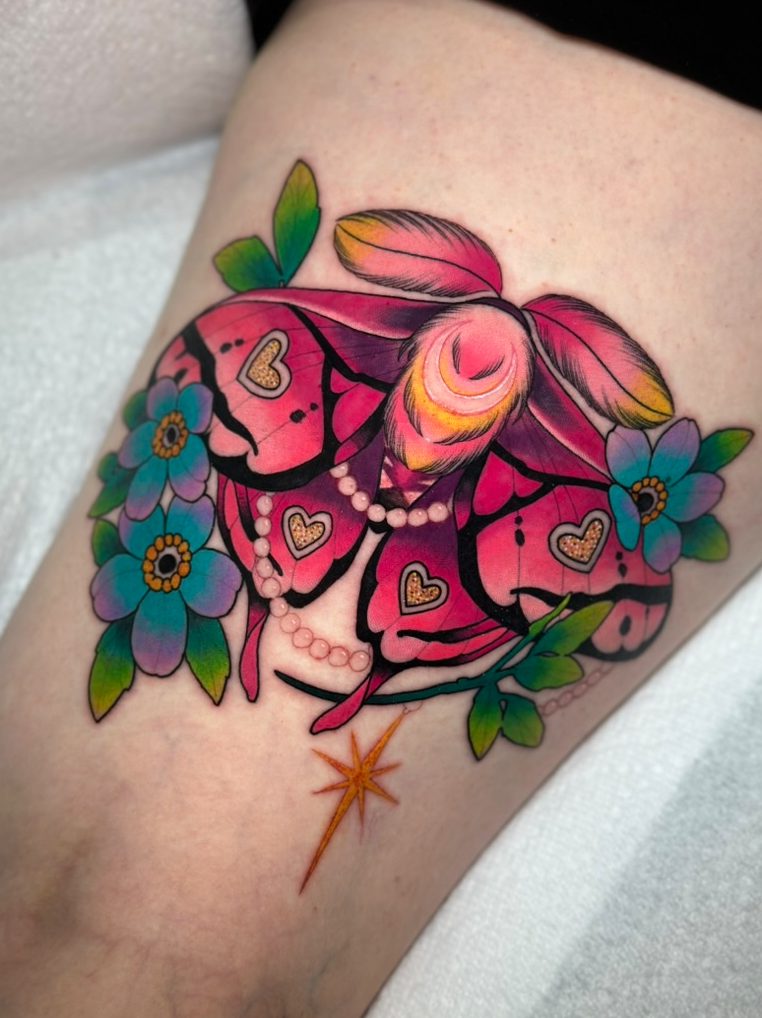 Pink moth and forget-me-nots tattoo on the thigh by Tia Berry, colour tattoo artist in Vancouver