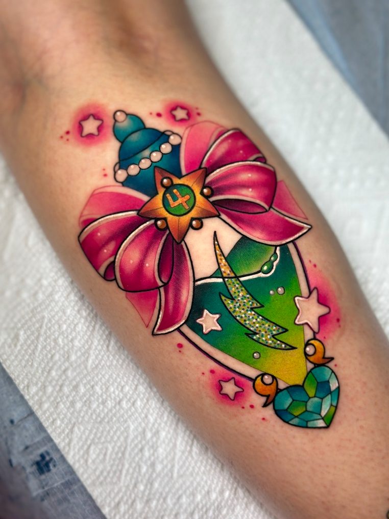Star wand and bow tattoo on the calf by Tia Berry, colour tattoo artist in Vancouver